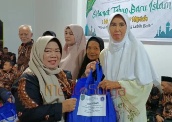 Anggota DPRD Barsel, Rida Sri Ahlina, menyerahkan bingkisan sembako kepada warga dalam acara tirakatan 1 Suro yang digelar Paguyuban Pakuwojo di Buntok.