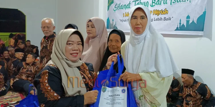 Anggota DPRD Barsel, Rida Sri Ahlina, menyerahkan bingkisan sembako kepada warga dalam acara tirakatan 1 Suro yang digelar Paguyuban Pakuwojo di Buntok.