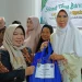Anggota DPRD Barsel, Rida Sri Ahlina, menyerahkan bingkisan sembako kepada warga dalam acara tirakatan 1 Suro yang digelar Paguyuban Pakuwojo di Buntok.